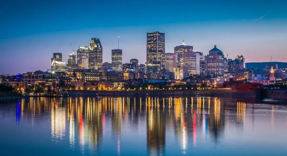 Ligne d’horizon de Montréal au crépuscule reflétée sur le fleuve