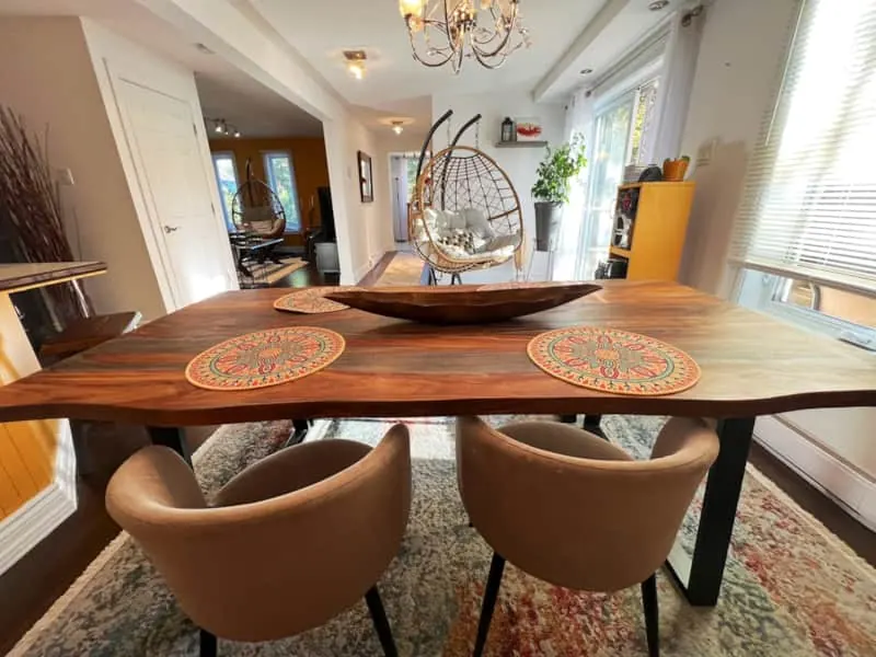 Salle à manger avec table en bois et fauteuils suspendus